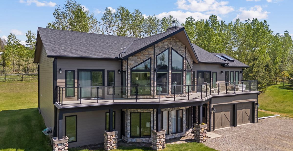 A home with large windows on an acreage in Foothills County, Alberta