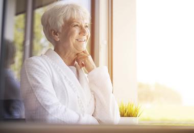 senior-woman-looking-out-of-replacement-window