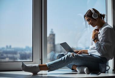 woman-working-on-a-computer-beside-filmed-window