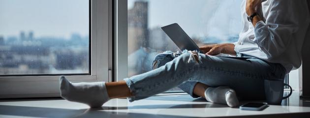 woman-working-on-a-computer-beside-filmed-window