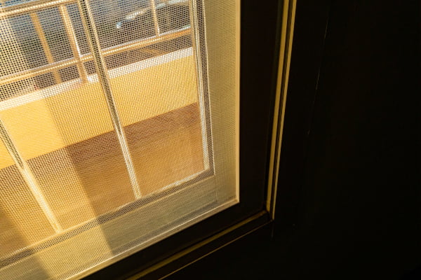 Custom retractable screen door with mesh panel installed inside a door frame