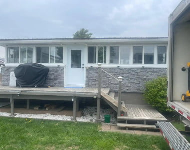 Completed residential window installation project with enclosed sunroom windows and exterior home renovation