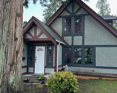 Black vinyl windows installed on a Tudor-style home in the Vancouver area